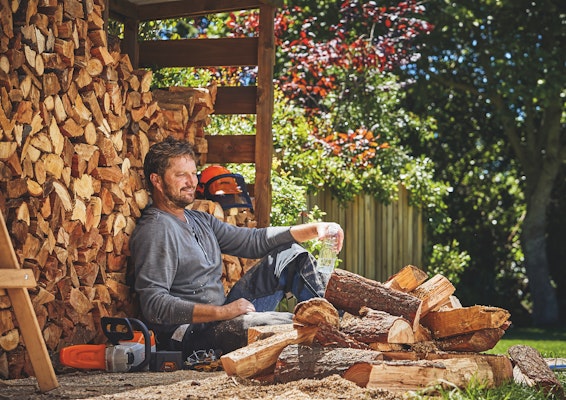 Man sitting next to firewood