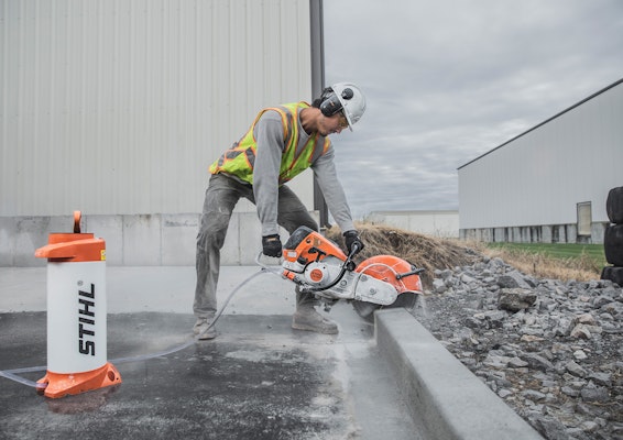 Construction worker using the TS 700 STIHL Cutquick&reg; on concrete with pressurized water tank