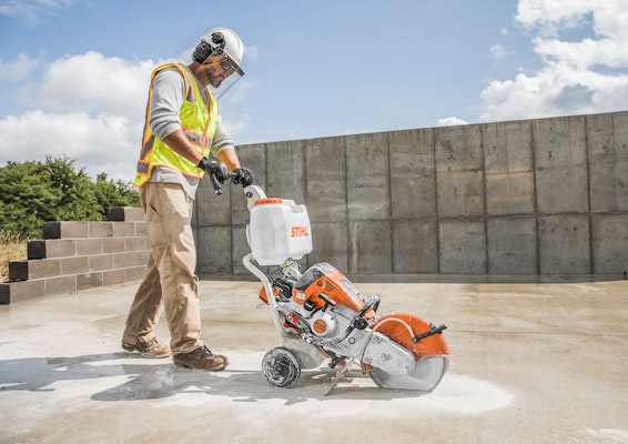 Construction worker using the TS 700 STIHL Cutquick&reg; on concrete with cart