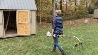 Woman putting STIHL trimmer in storage shed