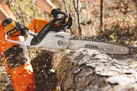 MS311 chainsaw cutting through a tree that is laying on the ground 