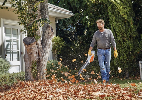 Man clearing leaves with BGA 57 blower