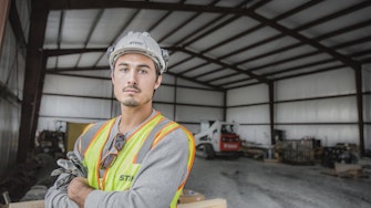 Man wearing construction ppe in a metal building.