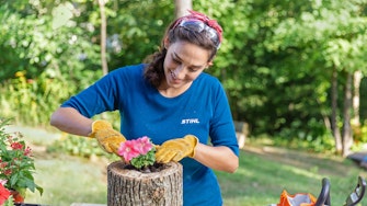 Woman placing flower in log planter
