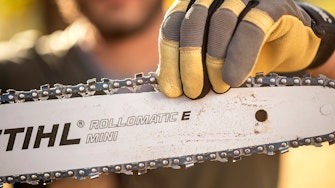 Man fixing Rollomatic E Mini Saw Chain with Guide Bar