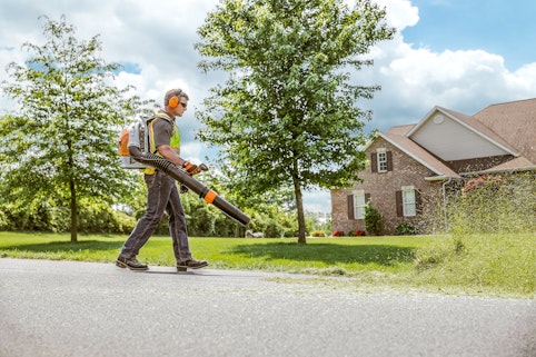 Landscaper using BR700 Backpack Blower to blow grass clippings