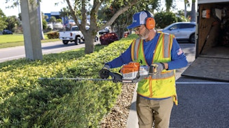 Professional landscaper working with STIHL hedge trimmer