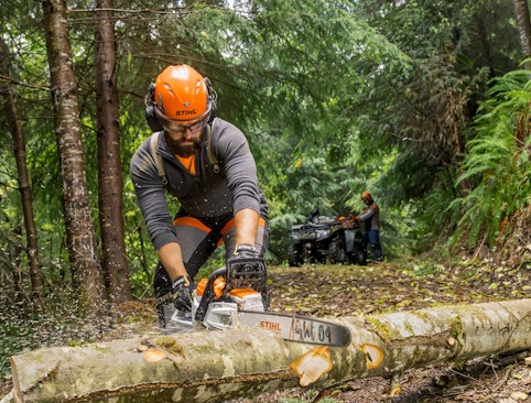 Pro using battery chainsaw in woods