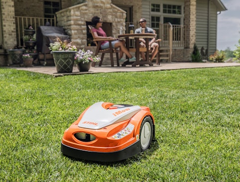 iMow mowing grass while people relax in the background.
