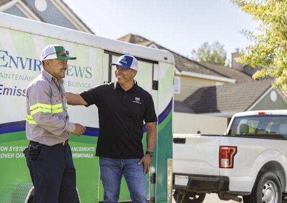 Landscapers standing by landscaping truck