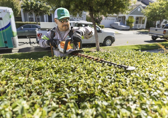 Landscaper using the HSA 94 R on a hedge.