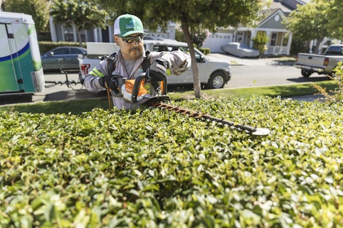 Landscaper using the HSA 94 R on a hedge.