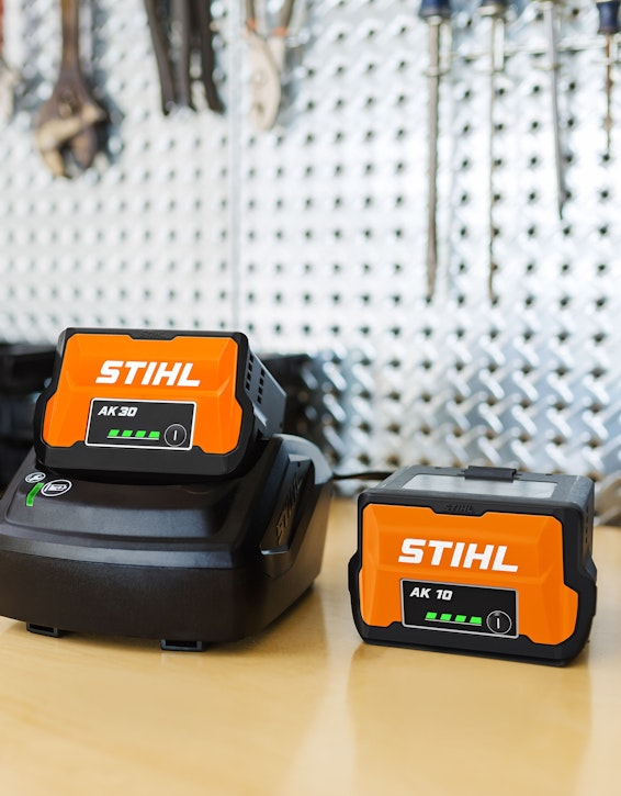 STIHL AK 10 and AK 30 Batteries with charger on workspace