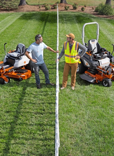 Two men standing with their STIHL RZ 261 and STIHL RZ 760i mowers on stripped lawn