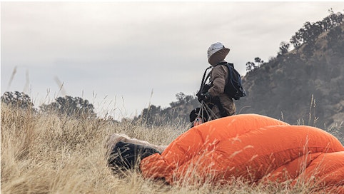 Smokejumper stands with orange parachute