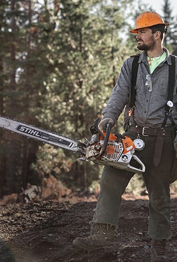Professional logger wearing personal protective equipment and holding STIHL MS 661 C-M MAGNUM® chainsaw
