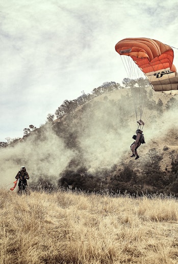 Smokejumpers parachute into wildland area