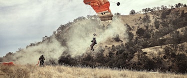 Smokejumpers parachute into wildland area