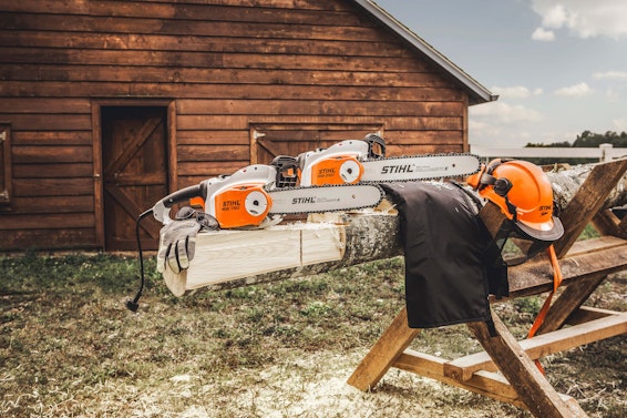 Group of STIHL electric chainsaws sitting on log