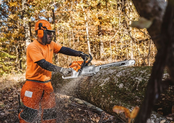 Man using STIHL MS 500i chainsaw to cut wood
