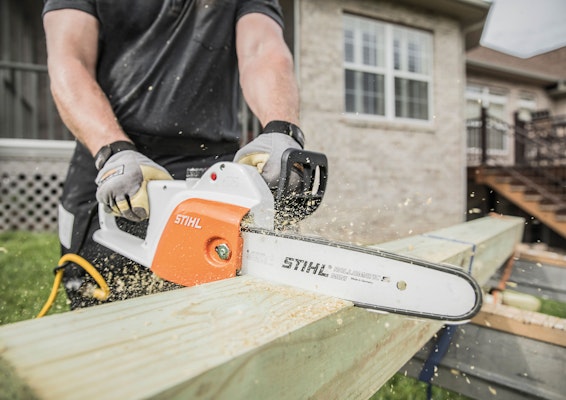 Person using STIHL MSE 141 C Chainsaw to cut wood